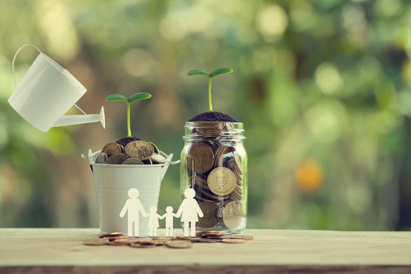 Banking and finance, Saving money concept: Water being poured on green sprout with glass bottle and bucket full of coins with family members. depicts investing money for earning growth.